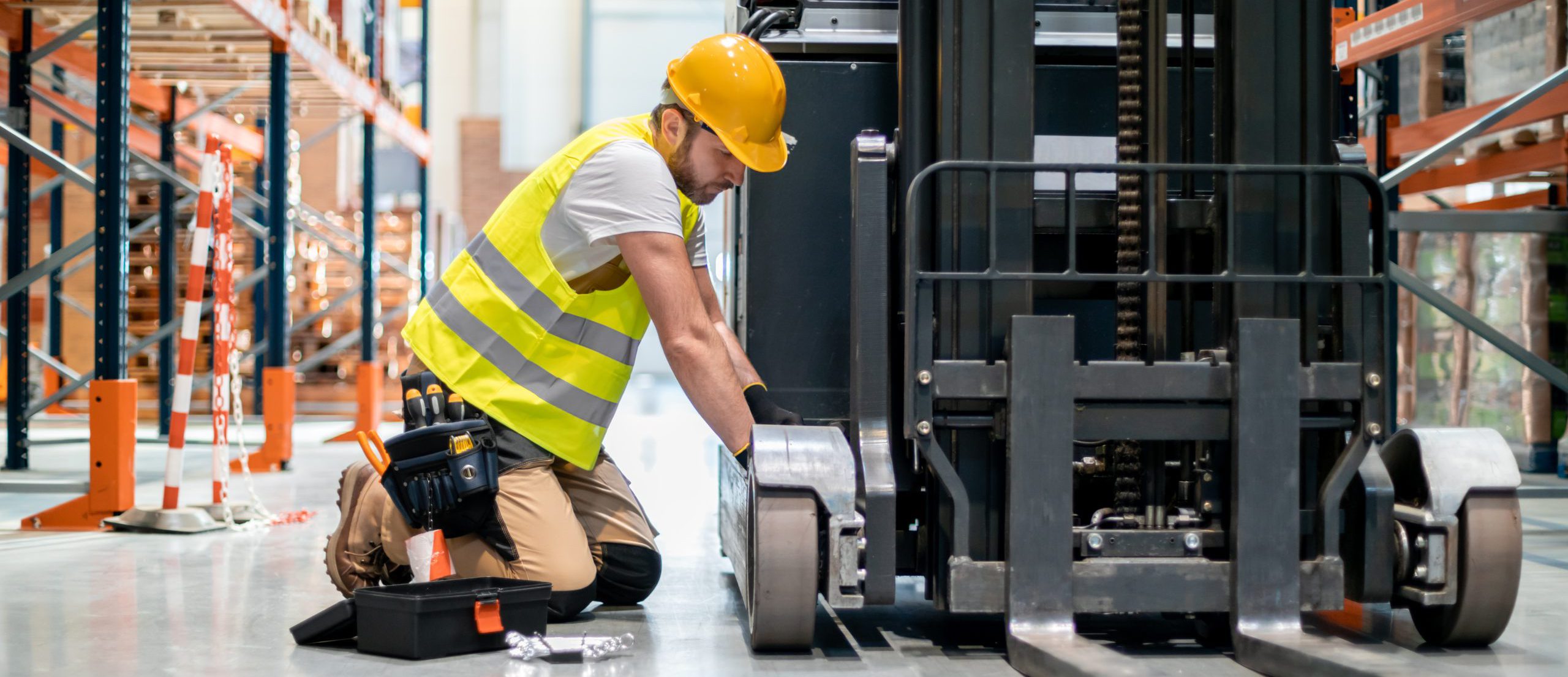 Mechanic repairing forklift in warehouse